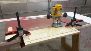 Routing shelf pin holes using my compact router, plunge base, and homemade jig.
